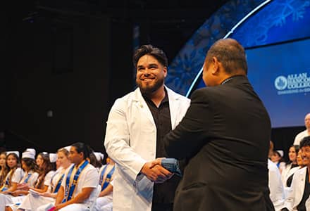 Man shaking hands as he graduates from nursing