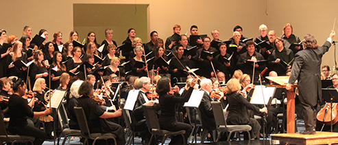 Choral group performing in front of an orchestra
